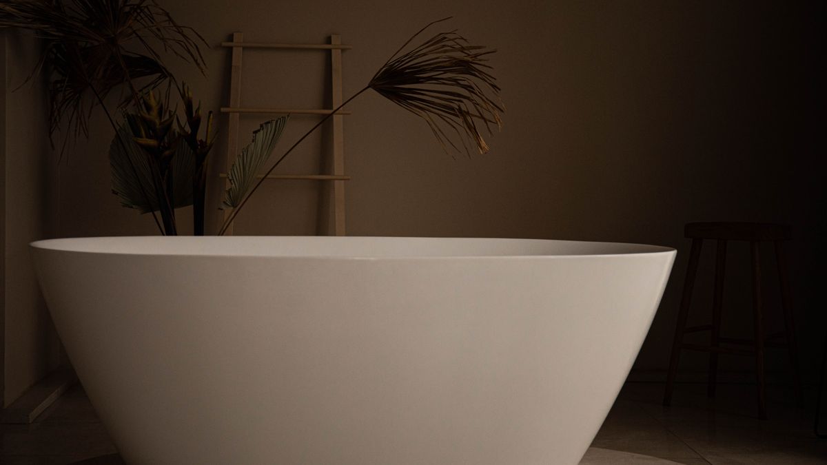 Sergey Meshkov / Pexels Elegant freestanding bathtub in a modern bathroom with plants and a wooden ladder.