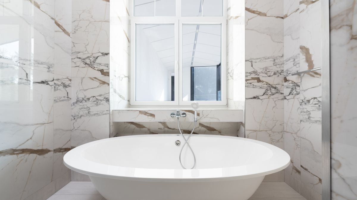 Max Vakhtbovych / Pexels Luxurious marble bathroom featuring a sleek freestanding bathtub and modern design elements.
