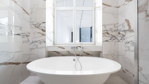 Luxurious marble bathroom featuring a sleek freestanding bathtub and modern design elements.