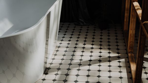 Minimalist bathroom with a freestanding tub and stylish hexagonal floor tiles, showcasing modern design.