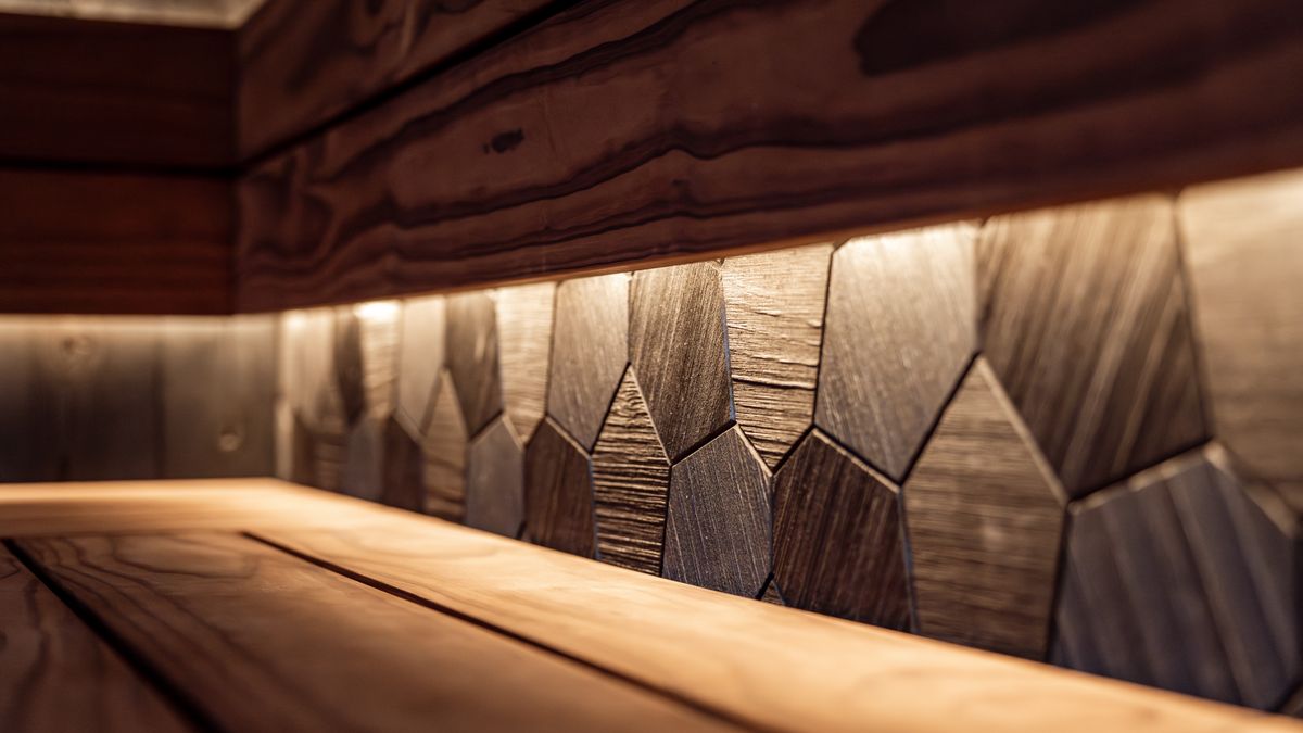 HUUM │sauna heaters / Pexels Interior of a modern sauna with LED lighting, featuring wooden benches and sleek wall panel design.