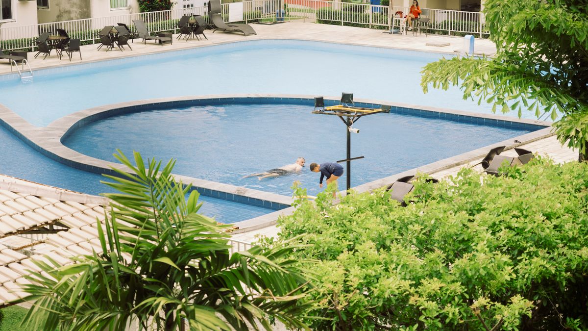 A peaceful scene with people enjoying a sunny day by a pool in Pernambuco, Brazil.