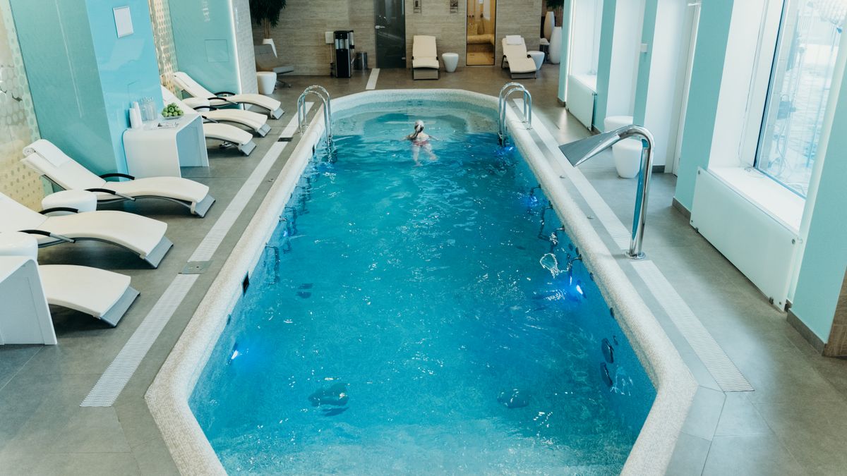 Bright indoor spa pool with lounge chairs and calm atmosphere, ideal for relaxation.