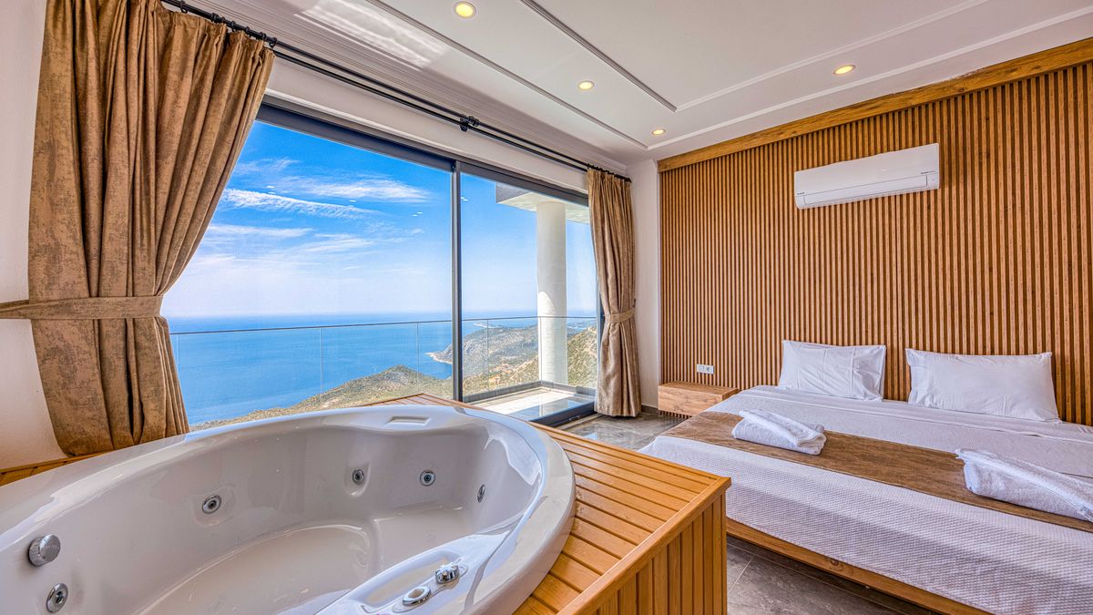 Luxurious hotel room with a stunning ocean view and private jacuzzi.
