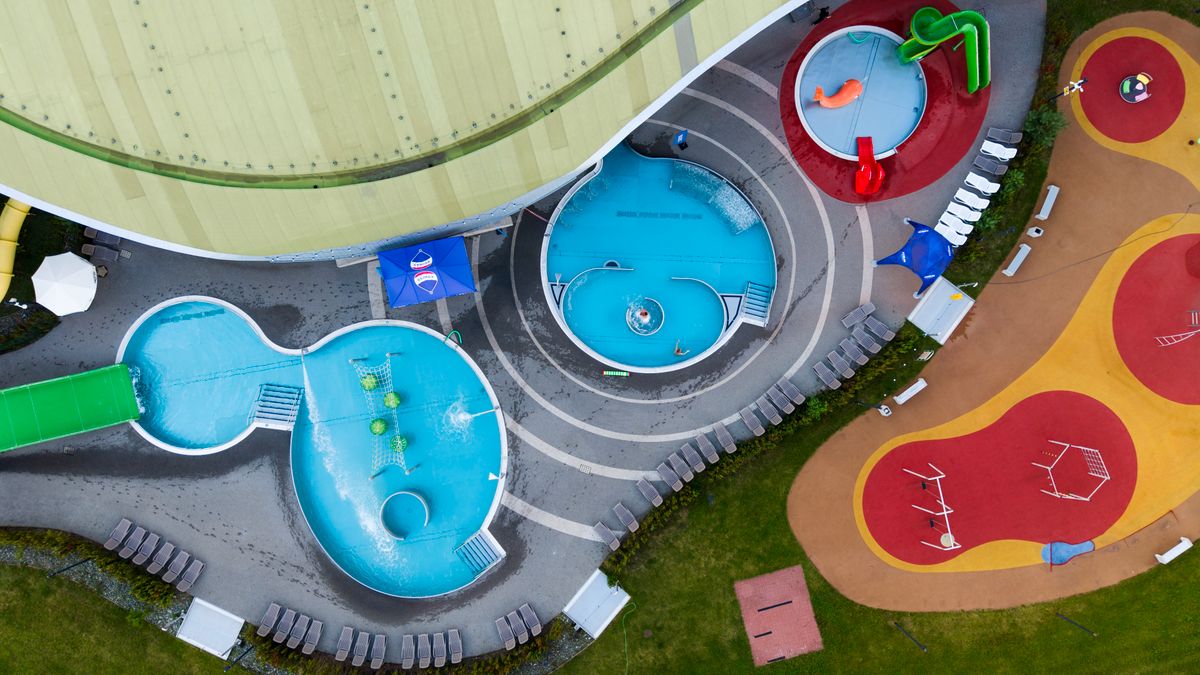 Vibrant aerial shot of a colorful outdoor water park with slides and pools.