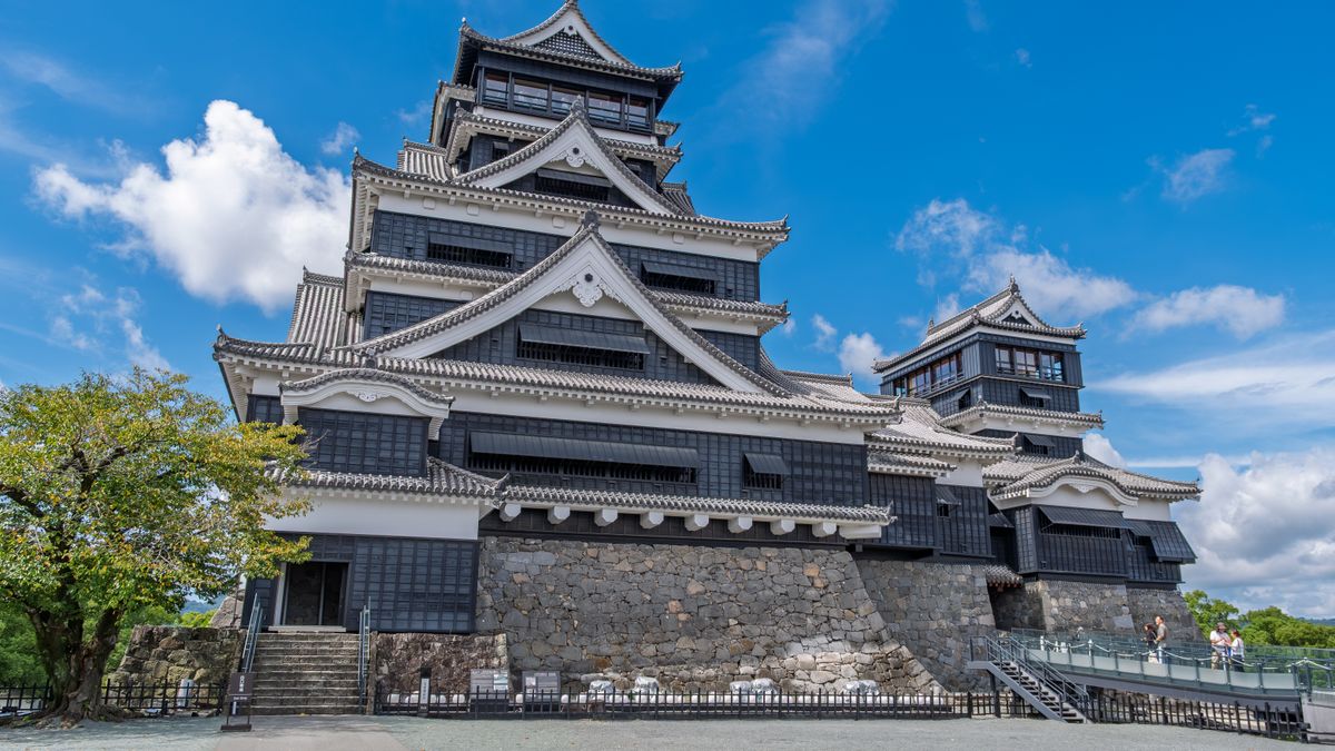 Discover the architectural beauty of Kumamoto Castle, standing tall in vibrant daylight.
