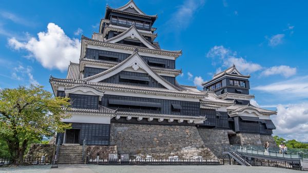 Discover the architectural beauty of Kumamoto Castle, standing tall in vibrant daylight.