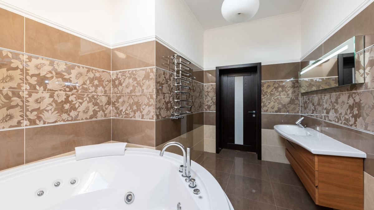 Max Vakhtbovych / Pexels Interior of contemporary bathroom with round ceramic bathtub and sink and wooden cabinet in daytime