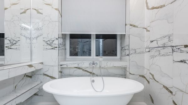 Modern bathroom featuring a luxurious marble design and a sleek freestanding bathtub.