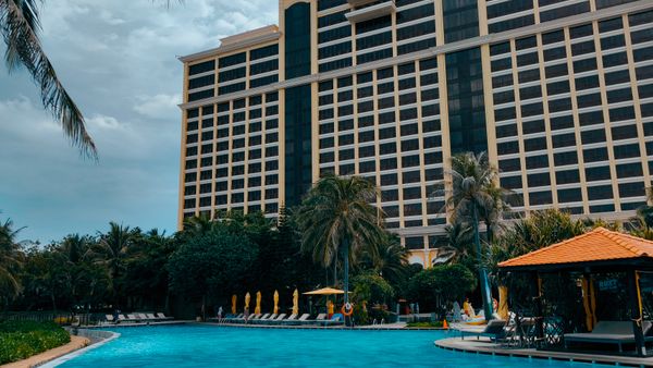 Stunning resort building with a tropical poolside setting and palm trees in a vibrant outdoor environment.
