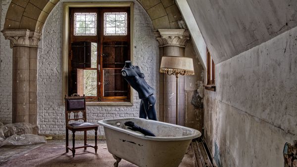 Atmospheric shot of an abandoned bathroom with a mannequin in a vintage tub.