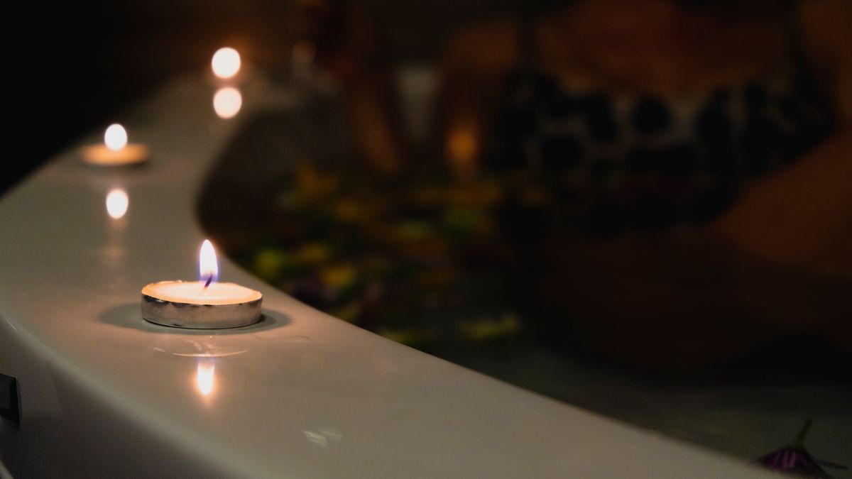 A relaxing bath with lit candles providing a romantic and soothing atmosphere.