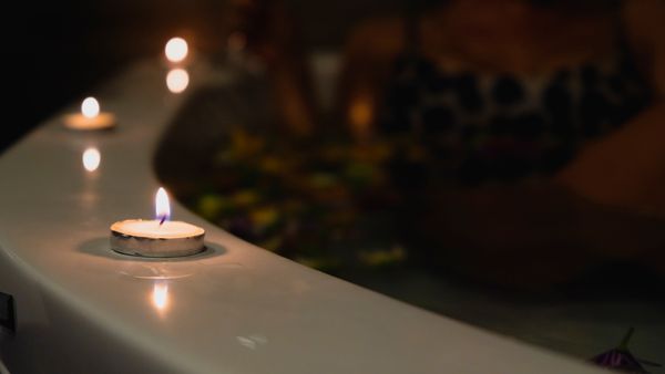 A relaxing bath with lit candles providing a romantic and soothing atmosphere.