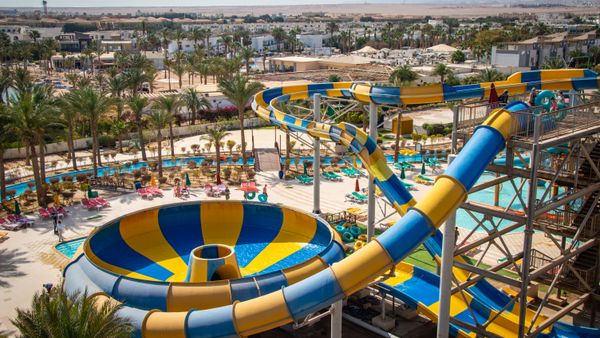 Vibrant water park featuring thrilling yellow and blue water slides under the sun.