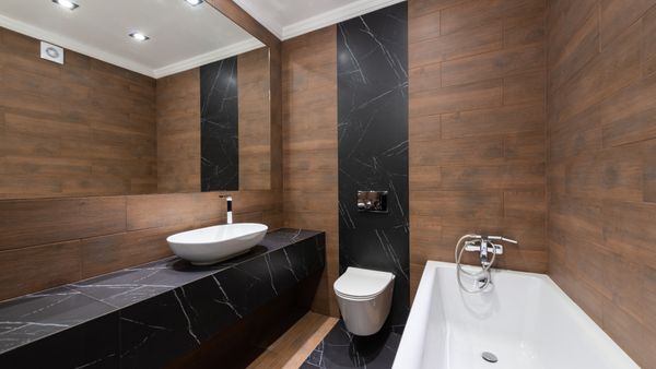Modern bathroom with wooden accents, sleek fixtures, and minimalist design.